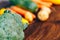 fresh salubrious colourful vegetables on wooden background, broccoli in focus, potatoes, carrots, zucchini unfocused, selected