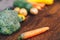 Fresh salubrious colourful vegetables on wooden background, carrot in focus, potatoes, broccoli, zucchini unfocused, selected