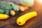Fresh salubrious colourful vegetables on wooden background, squash in focus, potatoes, carrots, broccoli, zucchini unfocused,