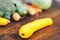 fresh salubrious colourful vegetables on wooden background, squash in focus, potatoes, carrots, broccoli, zucchini unfocused,