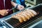 Fresh sausage and hot dogs grilling outdoors on a gas barbecue g