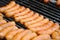 Fresh sausage and hot dogs grilling outdoors on a gas barbecue grill. Closeup of sausage on the grill