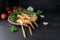 Fresh scampi, also called Norway Lobster or langoustine on a plate, tomatoes, garlic and herbs on a rustic wooden background,