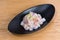 Fresh sea bass tartare garnished with lemon peel and slices of red onion