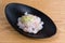 Fresh sea bass tartare garnished with lemon peel and slices of red onion