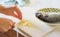 Fresh sea ocean fish hand chopping garlic meal preparation