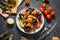 Fresh seafood salad, mussels, shrimp, fresh vegetables and herbs on black stone background