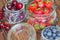 Fresh seasonal fruits in jars / blueberries, strawberries and cherries on a wooden table