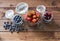 Fresh seasonal fruits in jars / blueberries, strawberries and cherries on a wooden table