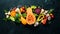 Fresh seasonal vegetables on a black stone background: Pumpkin, tomato, avocado, cucumber, onion, carrot. Autumn food.