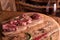 A fresh, seasoned Ribeye steak on a cutting board with pepper, rosemary. Near a glass of red wine