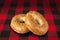 Fresh sesame seed bagel bread, isolated on a tartan red and black tablecloth