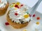 Fresh shortbread cake with cream filling, decorated with colorful decorative items. The cake is eaten with a spoon.