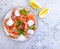 Fresh shrimp, ice, mediterranean gastronomy food plate ingredient lemon on a gray concrete background