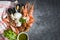 Fresh shrimps prawns squid mussels  spotted babylon shellfish crab and seafood sauce lemon on plate black stone background top