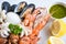 Fresh shrimps prawns squid mussels spotted babylon shellfish crab and seafood sauce lemon on white plate background - Cooked