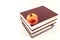 A fresh single ripe pomegranate is lying on a stack of books