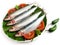 Fresh Slender Rainbow Sardine decorated with vegetables and herbs on a wooden pad.Selective Focus