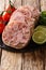 Fresh sliced brawn served with tomatoes, lime and cilantro closeup on a slate board. vertical