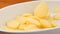 Fresh sliced potato dropping in oven dish in slow motion