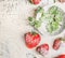 Fresh sliced Strawberries with powdered sugar and mint leaves in bowl on light rustic background