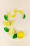 Fresh slices of yellow lemon lime fruit with green leaf and ice cube laid out on a pastel background in the form of Golden Ratio