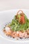 Fresh smoked salmon salad,  served with rucola and baby spinach and pieces of vegetables,  decorated with herbs,  placed on white