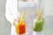 Fresh smoothie detox vegetable carrot lettuce and cucumber in hands on the pastel background