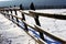 Fresh snow on wooden corral fence at winter rural scene