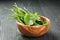 Fresh sorrel leaves in olive bowl on oak wood