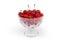 Fresh sour cherries in the glass cup on white background