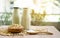 Fresh soybean seeds in brown wooden bowl with sugar in spoon and two bottles of soy milk on the table,  under sunlight morning