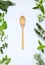 Fresh spicy and medicinal herbs on white background and wooden spoon. Border from various herb - rosemary, oregano, sage, marjoram