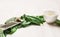 Fresh spinach leaves with grate, nutmeg and bowl of oil on white wooden