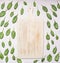 Fresh spinach leaves have been laid out around a vintage white cutting board, frame, space ftext, top view