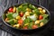 Fresh spinach salad, salted lupine beans, tomatoes and olives close-up in a plate. horizontal