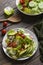 Fresh spring salad with lettuce, cucumber, cherry tomatoes, radishes, spring onion and avocado with balsamic glaze and olive oil