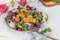 Fresh spring salad with rucola, lettuce, blueberries, radish, beet and slices of peach. White background with free text space