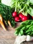 Fresh Spring vegetables and herbs - carrots, ramson, radish, dill, garlic, cabbage on a wood background. Spring harvest of fresh