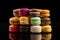 Fresh Stack of three multicolored Macaron or Macaroons on Black background, pastel colors, stacked, colorful, cafe desserts. Rows