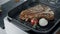 Fresh steak frying at griddle pan. Closeup beef with vegetables cooking at grill