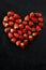 Fresh strawberries array heart shape on black background. Love concept. Valentine's Day Concept. Winter Concept.