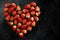 Fresh strawberries array heart shape on black background. Love concept. Valentine's Day Concept. Winter Concept.