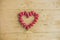 Fresh strawberries array heart shape on old wooden background