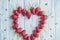 Fresh strawberries array heart shape on old wooden background