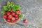 Fresh strawberries in a basket on rustic concret background top view. Healthy food on grey table mockup. Delicious, sweet, juicy