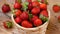 Fresh strawberries in basket spinning on wooden table