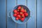 Fresh strawberries in a blue colander on the table