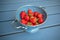 Fresh strawberries in a blue colander on the table