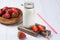 Fresh strawberries and bottle of milk with straw, wooden table